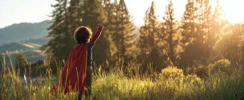 The child in a superhero cape standing in a sunlit field. photo