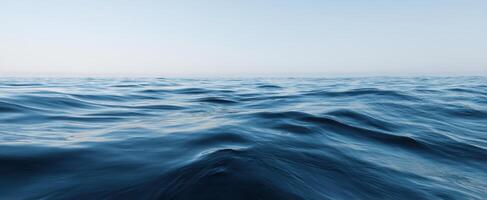 The serene blue ocean waves under a clear sky at dawn. photo