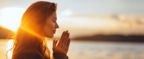 A woman is praying in front of the sun photo