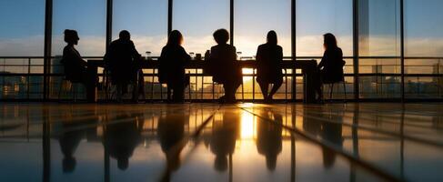 The silhouettes of business professionals meeting during a stunning sunset. photo