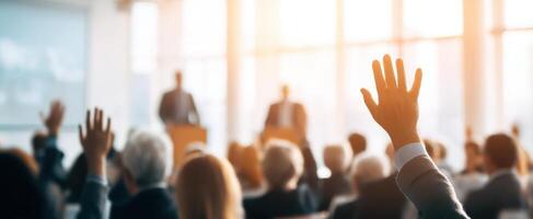 The engaged audience raising hands in a conference setting. photo