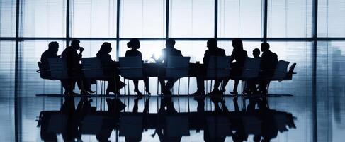 The silhouettes of business professionals engaged in a strategic meeting. photo