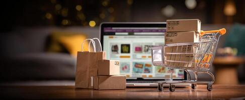 The shopping cart filled with packages beside a laptop displaying an online store. photo