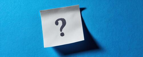 The question mark on a sticky note against a vibrant blue background. photo