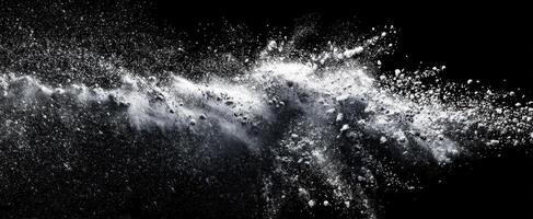 The dramatic splash of white powder against a black background. photo