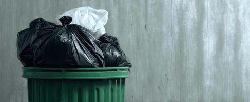 The green garbage bin overflowing with black and white trash bags. photo