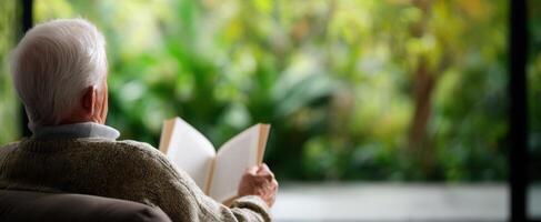 The elderly man enjoying a peaceful moment while reading a book in nature. photo