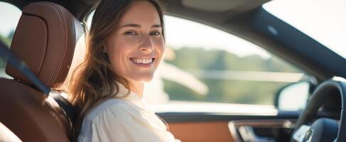 The smiling woman in a car enjoying a beautiful day outdoors photo