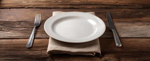 The elegant white plate beautifully arranged on a rustic wooden table. photo
