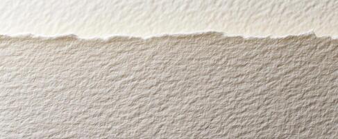 The textured surface of handmade paper with a torn edge in natural light photo
