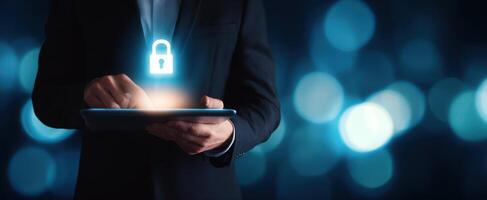 The businessman interacting with a tablet featuring a glowing security lock icon. photo