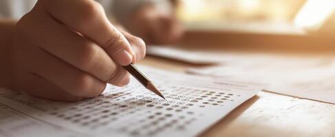 The focused student completing a test with a pencil on an answer sheet. photo