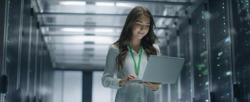 The modern woman working with a laptop in a high-tech server environment. photo