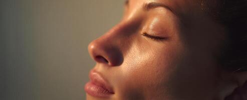 The serene beauty of a woman's peaceful face illuminated by soft sunlight. photo