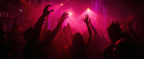 The vibrant dance party atmosphere with raised hands and colorful lights. photo