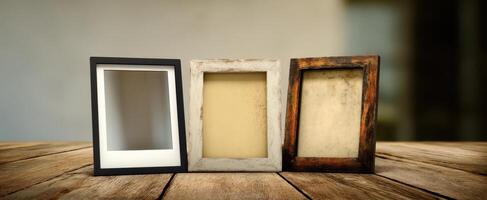 The collection of empty photo frames showcasing various styles on a wooden table.