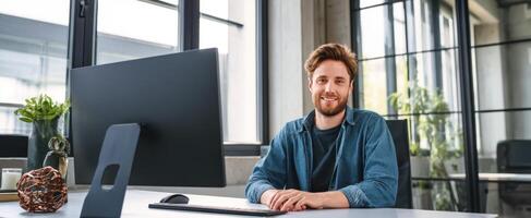 The friendly man in a modern office setting with a computer. photo