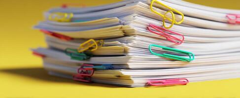 The colorful stack of documents held together with paper clips. photo