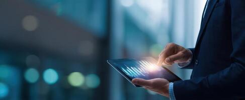 The businessman utilizing a tablet to analyze financial data and trends. photo