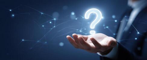 The hand holding a glowing question mark representing curiosity and inquiry. photo