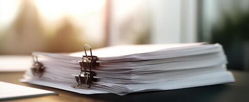 The organized stack of documents with clips on a modern office table. photo
