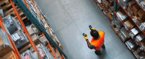 The worker using a smartphone for inventory management in a warehouse setting. photo