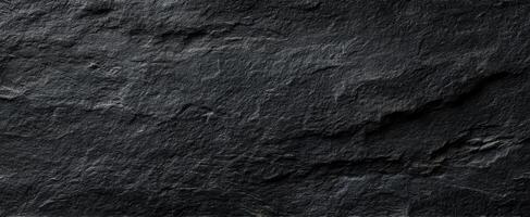 The textured surface of dark slate rock enhancing any natural backdrop. photo