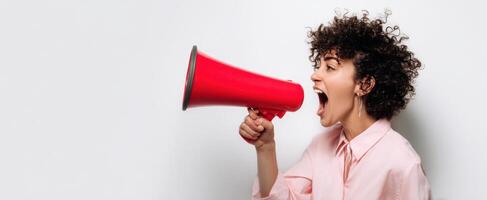 The passionate woman shouting through a megaphone expressing her message. photo