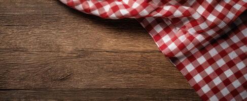 The checkered tablecloth elegantly drapes over a rustic wooden table photo