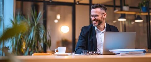 The smiling professional man enjoying his work at a modern office desk. photo