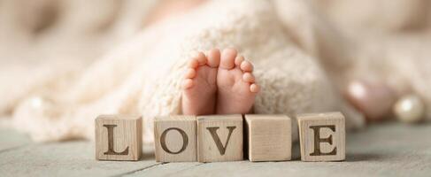 The adorable baby feet with love blocks laid beside them. photo