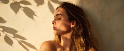 The woman basking in sunlight with elegant shadows casting beautifully around her. photo