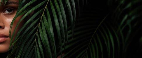 The serene portrait of a woman framed by lush green leaves. photo