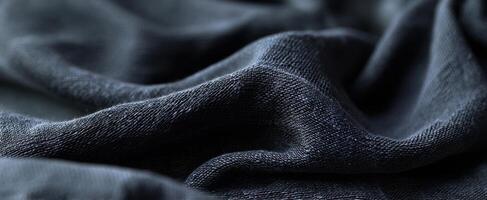 The luxurious texture of a black fabric displaying elegant folds and waves. photo