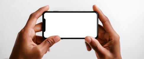 The hands holding a smartphone with a blank screen for customization. photo