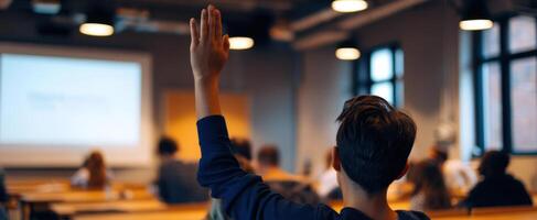 The engaged student raising a hand during a classroom presentation. photo