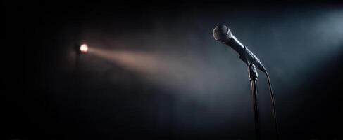 The microphone ready for performance under a dramatic spotlight on stage. photo