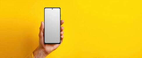 The modern smartphone held in hand against a vibrant yellow background. photo