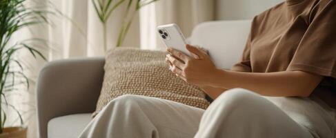 The person using a smartphone while sitting comfortably on a couch photo