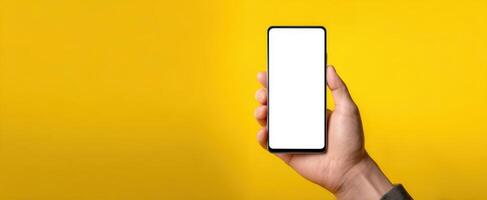 The modern smartphone held in a hand against a vibrant yellow background. photo