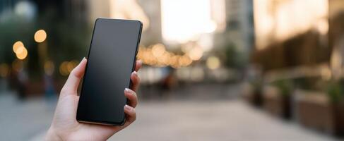 The smartphone held in hand against a vibrant urban backdrop. photo