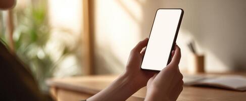 The smartphone held by a person in a serene home workspace setting. photo