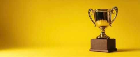 The shiny trophy symbolizing achievement and success against a vibrant yellow background. photo
