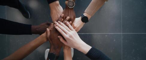 The joining of hands symbolizing teamwork and unity in a diverse group. photo