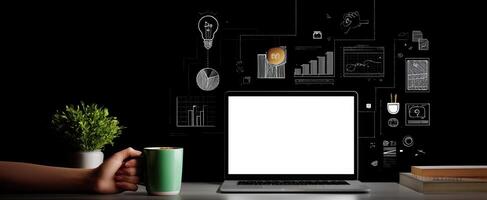 The laptop on a stylish desk with coffee and creative graphics surrounding it. photo