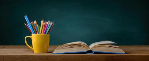 The open book and colorful pencils on a wooden desk background. photo