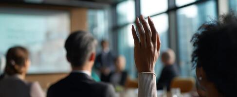 The person raising a hand during a corporate meeting or presentation. photo