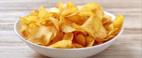 A bowl of chips sitting on a wooden table photo