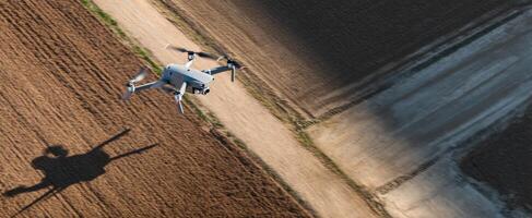 The drone flying over a harvested field casting an intriguing shadow. photo