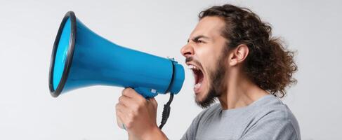 The man yelling passionately into a blue megaphone against a plain background. photo